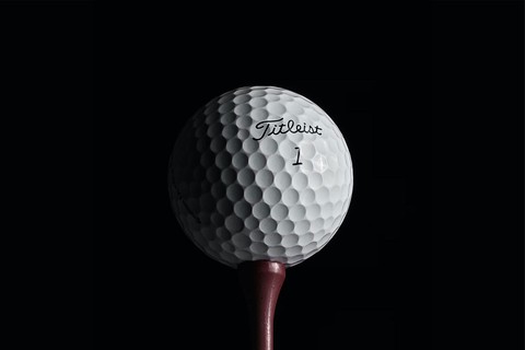 A brand new white Fitleist ball on copper tee