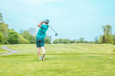 A man using a hybrid club on the fairway